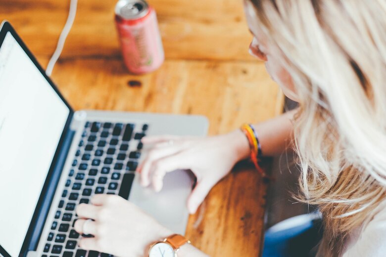 Une femme blonde tape sur le clavier de son ordinateur