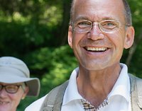 [Bitte in "Italienisch" uebersetzen:] Ein lächelnder Mann auf grünem Hintergrund