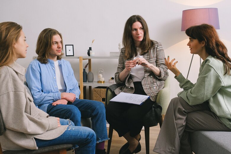 Quatre personnes assises sur des chaises discutent entre elles