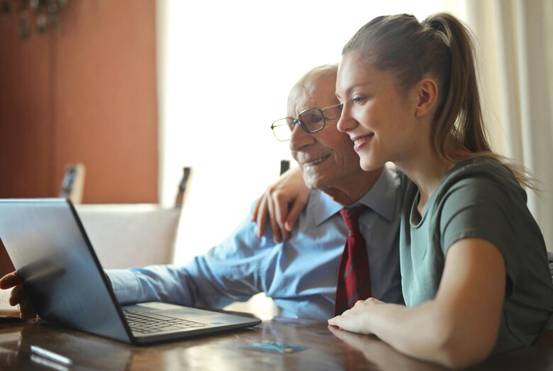 Un père et sa fille regardent un ordinateur