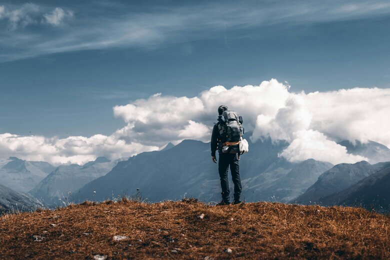 Une personne en haut d'une montagne, regardant l'horizon