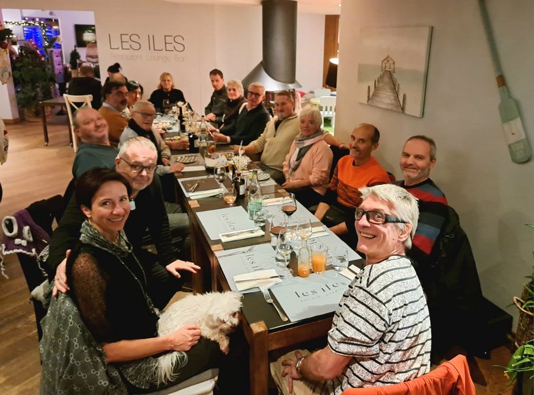 FRAGILE Valais Groupe de personnes assises autour d'une table