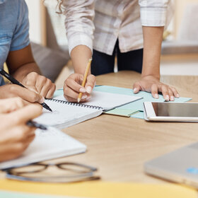 Des personnes autour d'une table regardent des documents