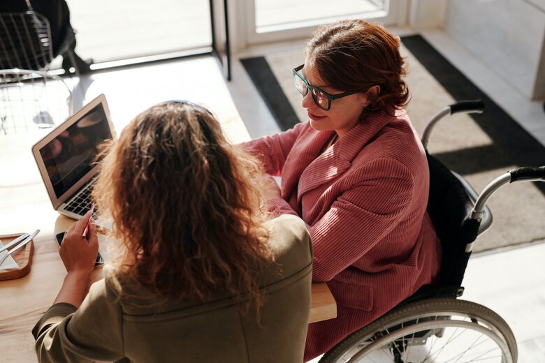 Une femme en chaise roulante en discussion avec une autre femme