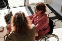 Une femme en chaise roulante en discussion avec une autre femme