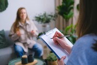 Une personne prenant des notes pendant qu'une autre personne parle