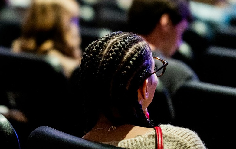 Une femme de dos, assise dans une aula