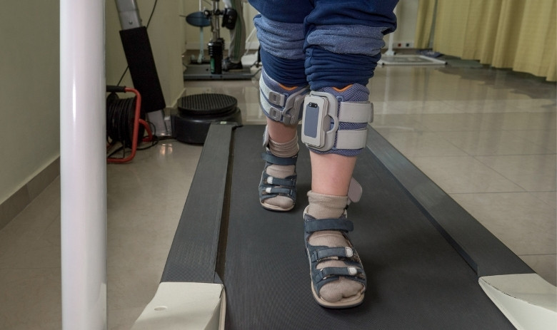 Gehtraining Die Beine einer Person, die sich auf einem Laufband fortbewegt.