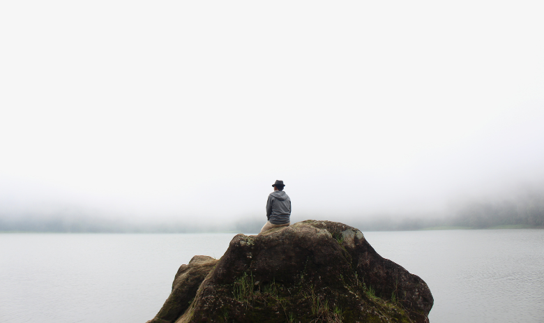Silence Un homme est assis sur un rocher